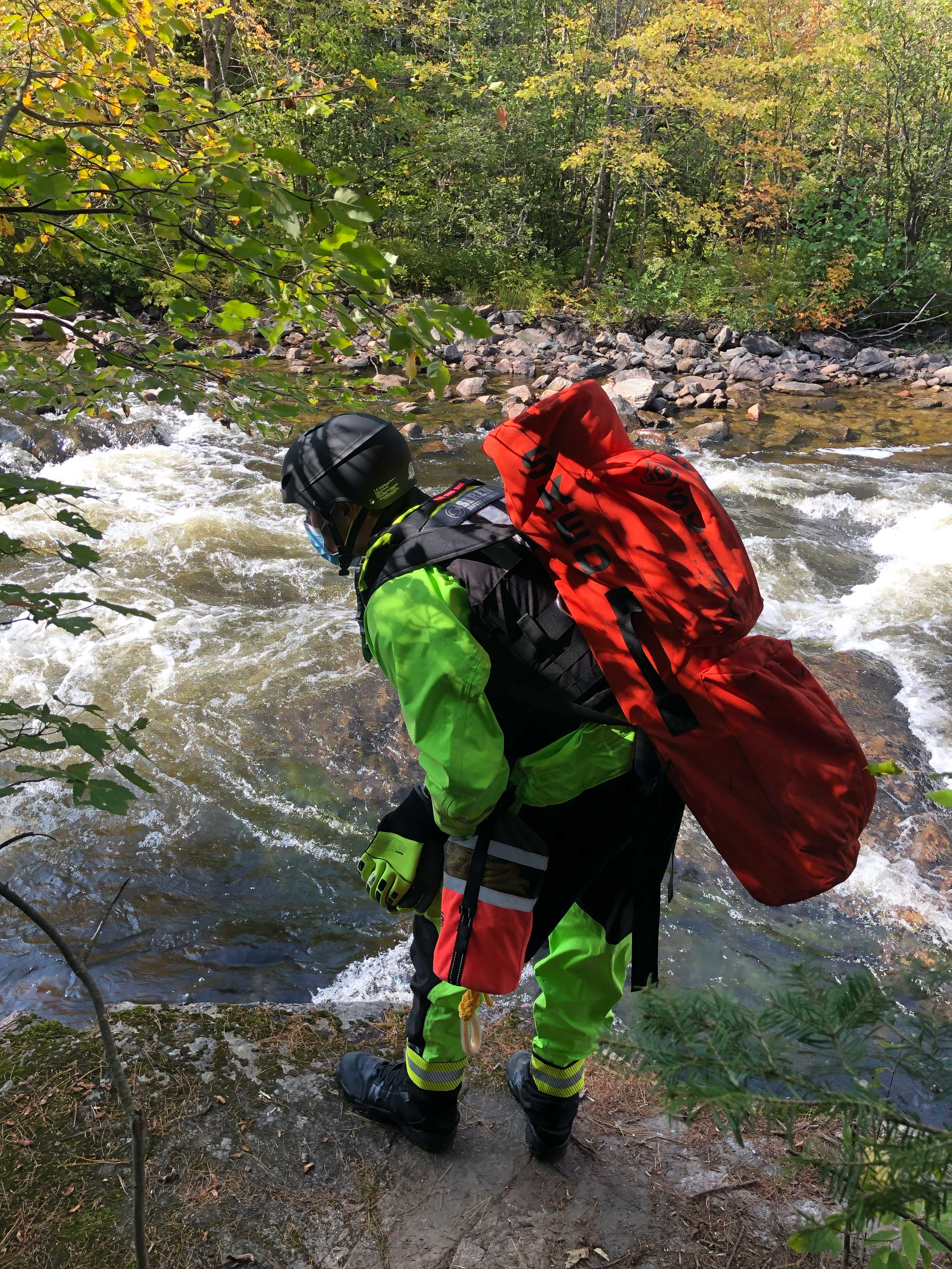 Siren Safety swiftwater rescue technician with SKED at river rapids