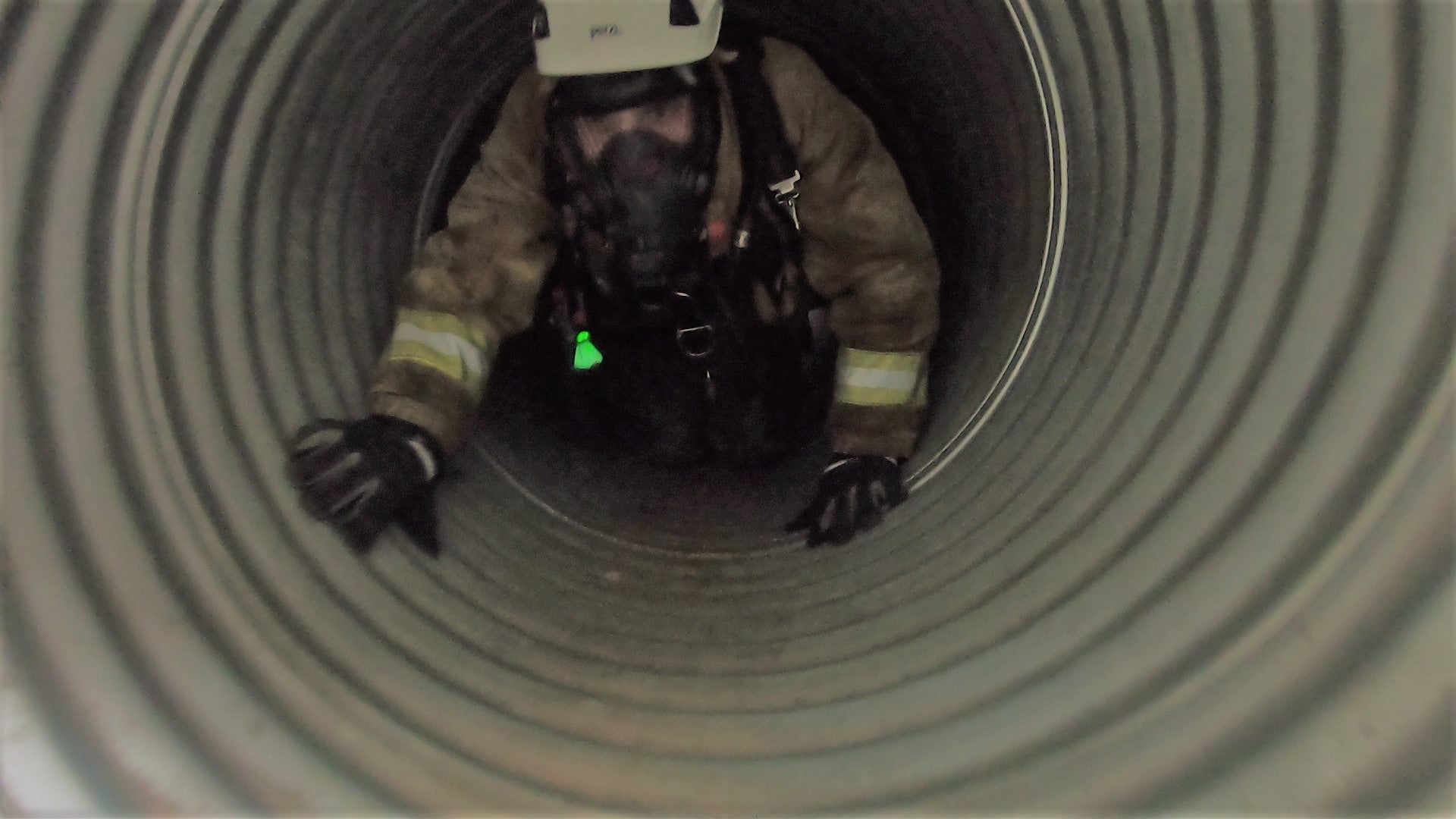 Siren Safety rescue technician with SCBA entering a confined space culvert